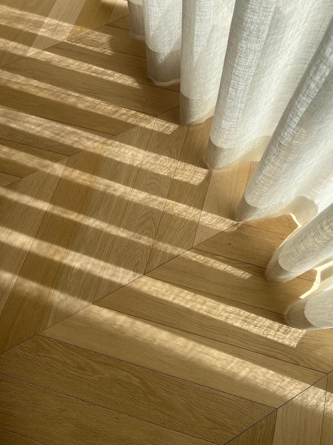 Hongaarse punt parket met zonlicht door vitrage
