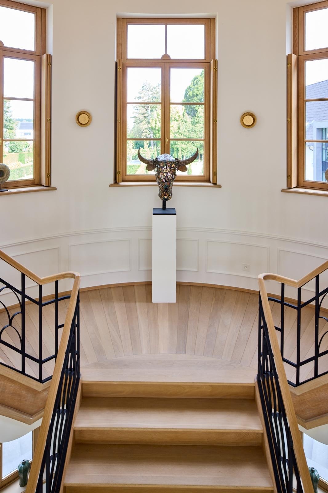 Gebogen eiken trap met smeedijzeren balustrade in een villa, door Grutman Floor Concepts